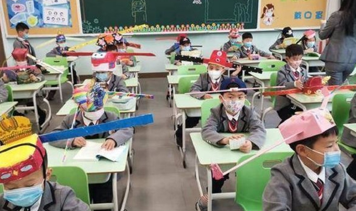 Les enfants chinois portent des chapeaux de distanciation sociale qu'ils ont eux-mmes fabriqus