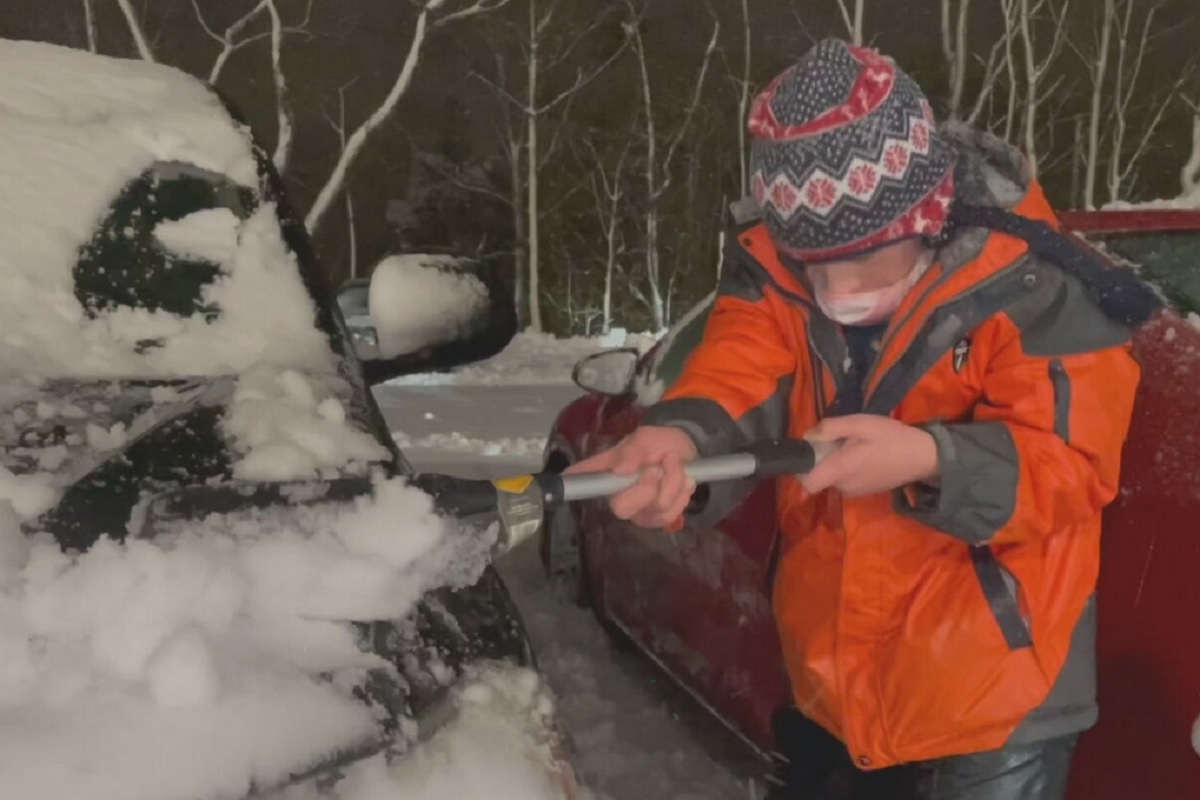 Un jeune garon dblaie les voitures des travailleurs de la sant aprs une importante chute de neige